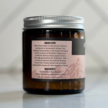 Jar of shea butter with a label on a neutral background