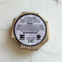 Bar of soap in compostable packaging with a label on a marble surface